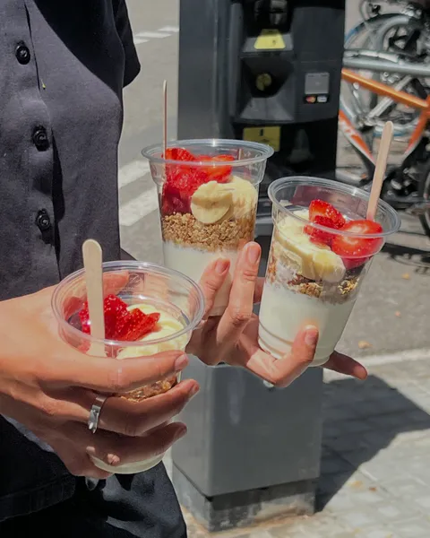 Tres vasos de yogur con granola, plátano y fresas